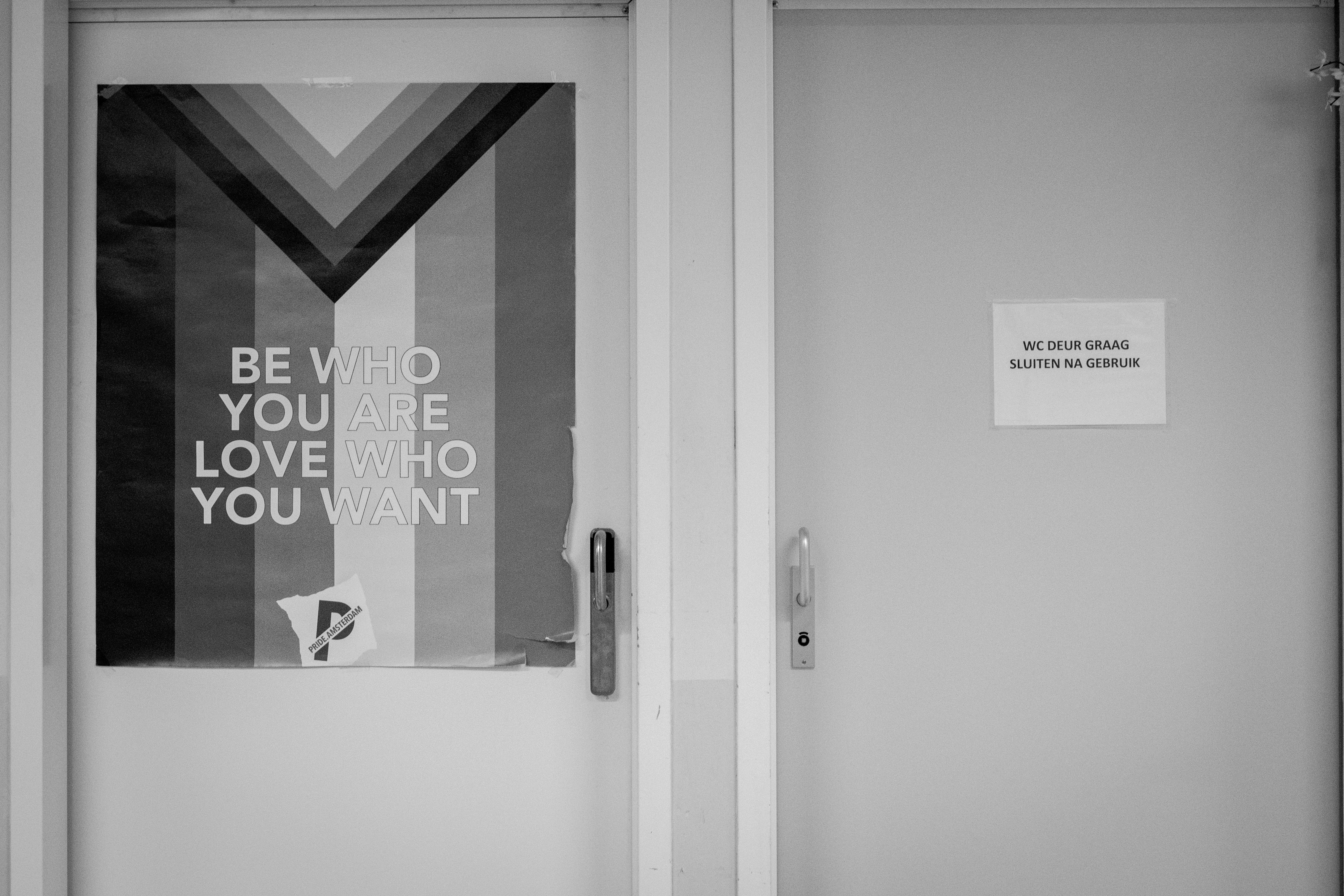 a black and white photo of a door with a sign on it