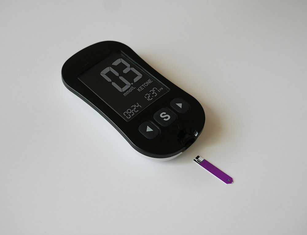 a thermometer and a purple pen on a white surface