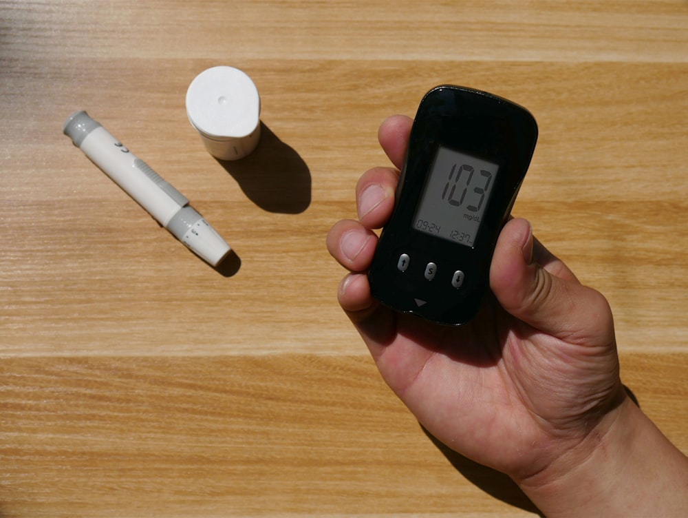 a person holding a smart phone next to an electronic device