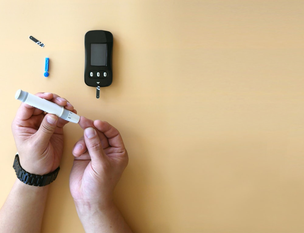 a person holding a cigarette next to an electronic device