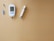 A blood glucose meter displays a reading of 103 mg/dL, accompanied by a lancet and test strip on a plain beige background. The glucometer is white with a digital screen, and there is a cylindrical pen-like device nearby.