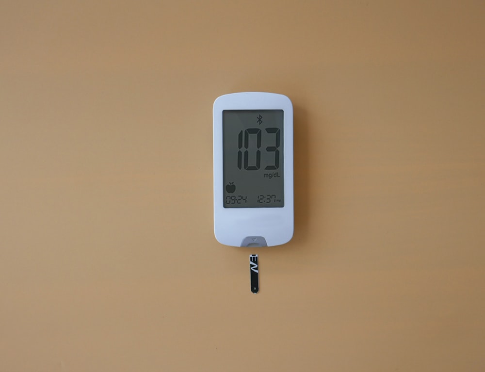 a digital thermometer on a tan wall
