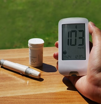 a person holding a thermometer next to a bottle of pills