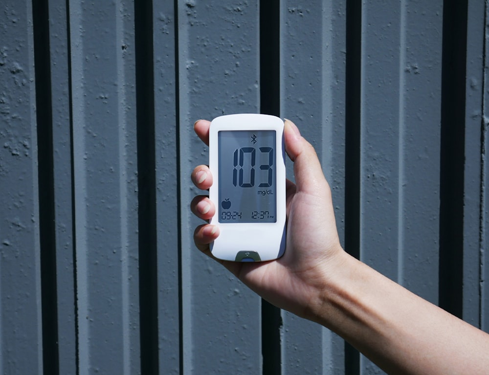 a person holding a digital thermometer in their hand