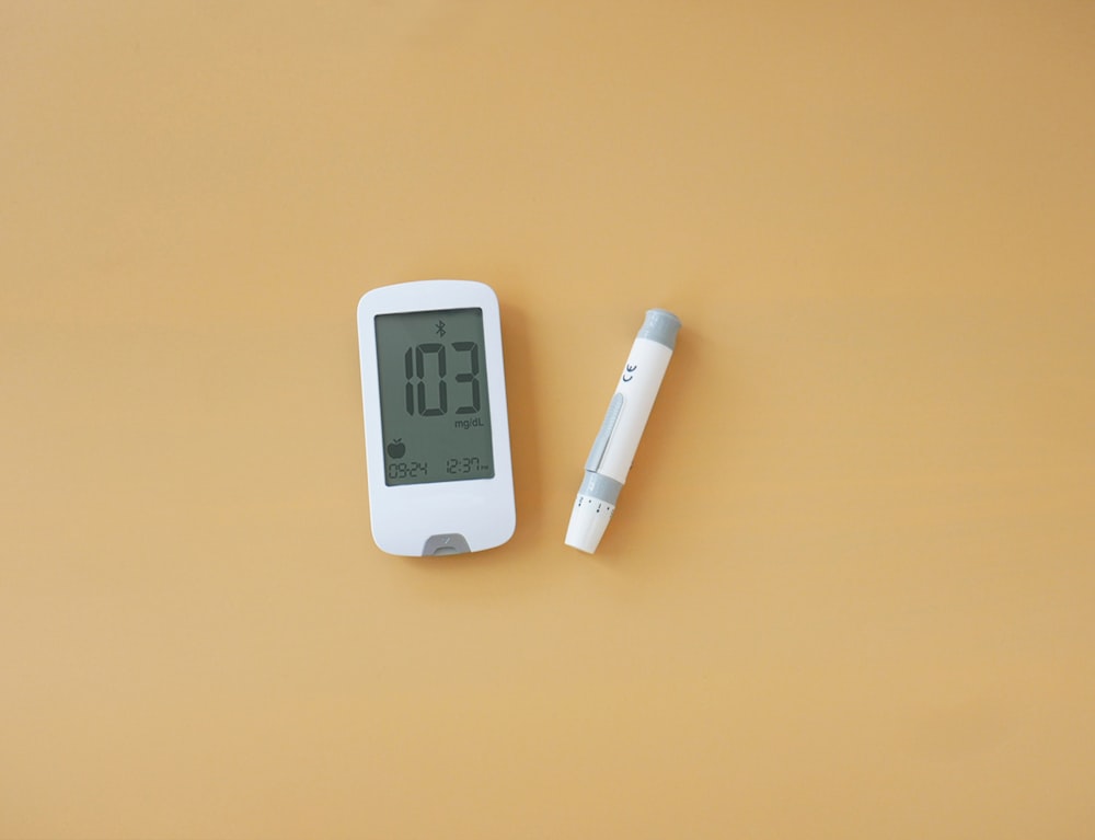 a thermometer and a pen on a yellow surface