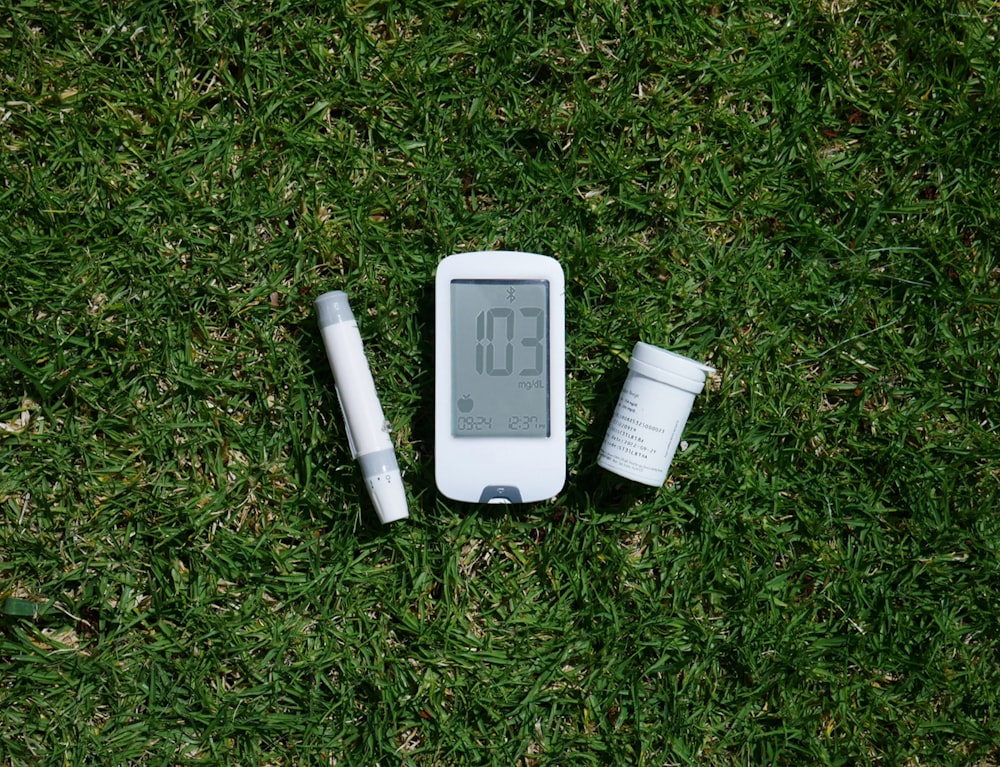 an electronic device with a thermometer sitting on the grass