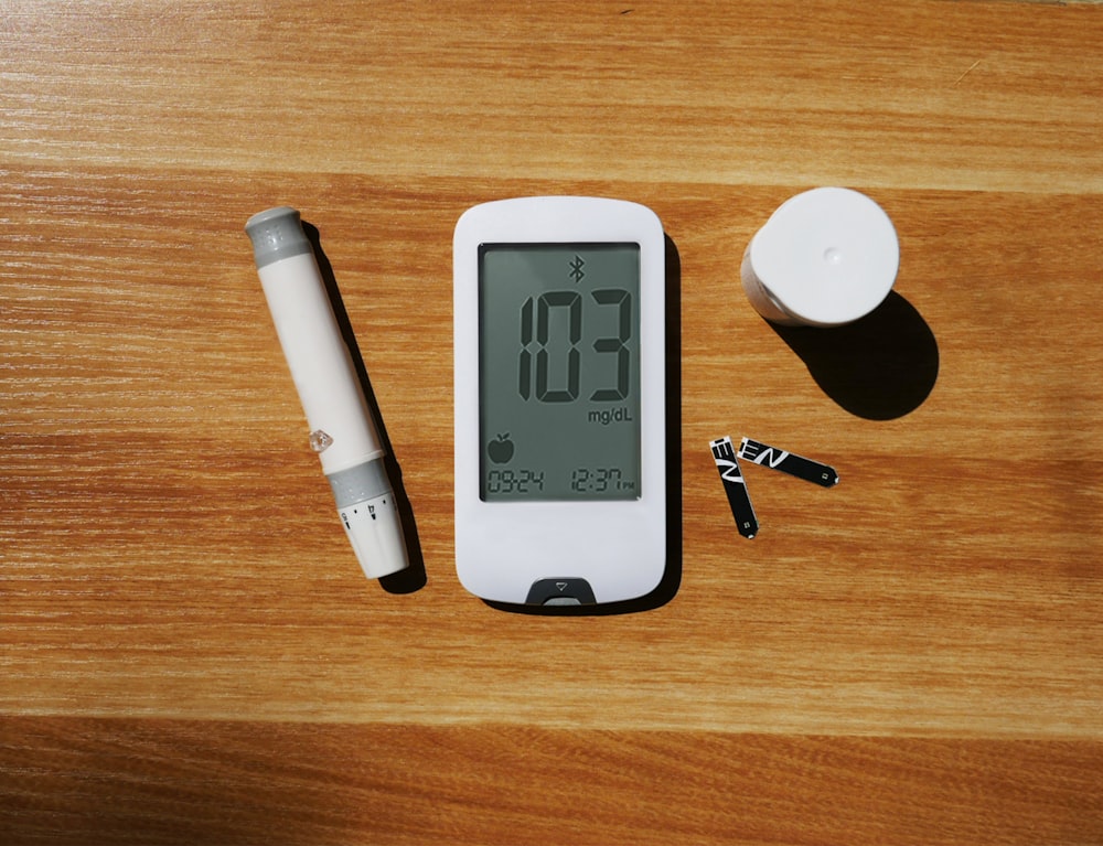 una mesa de madera cubierta con un teléfono inteligente y un bolígrafo