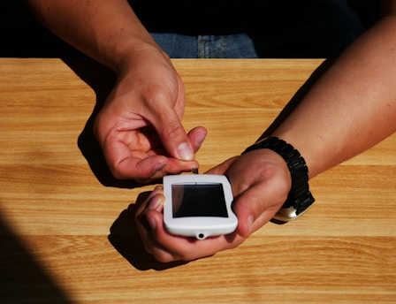 a person holding a smart phone for diabetes in their hands