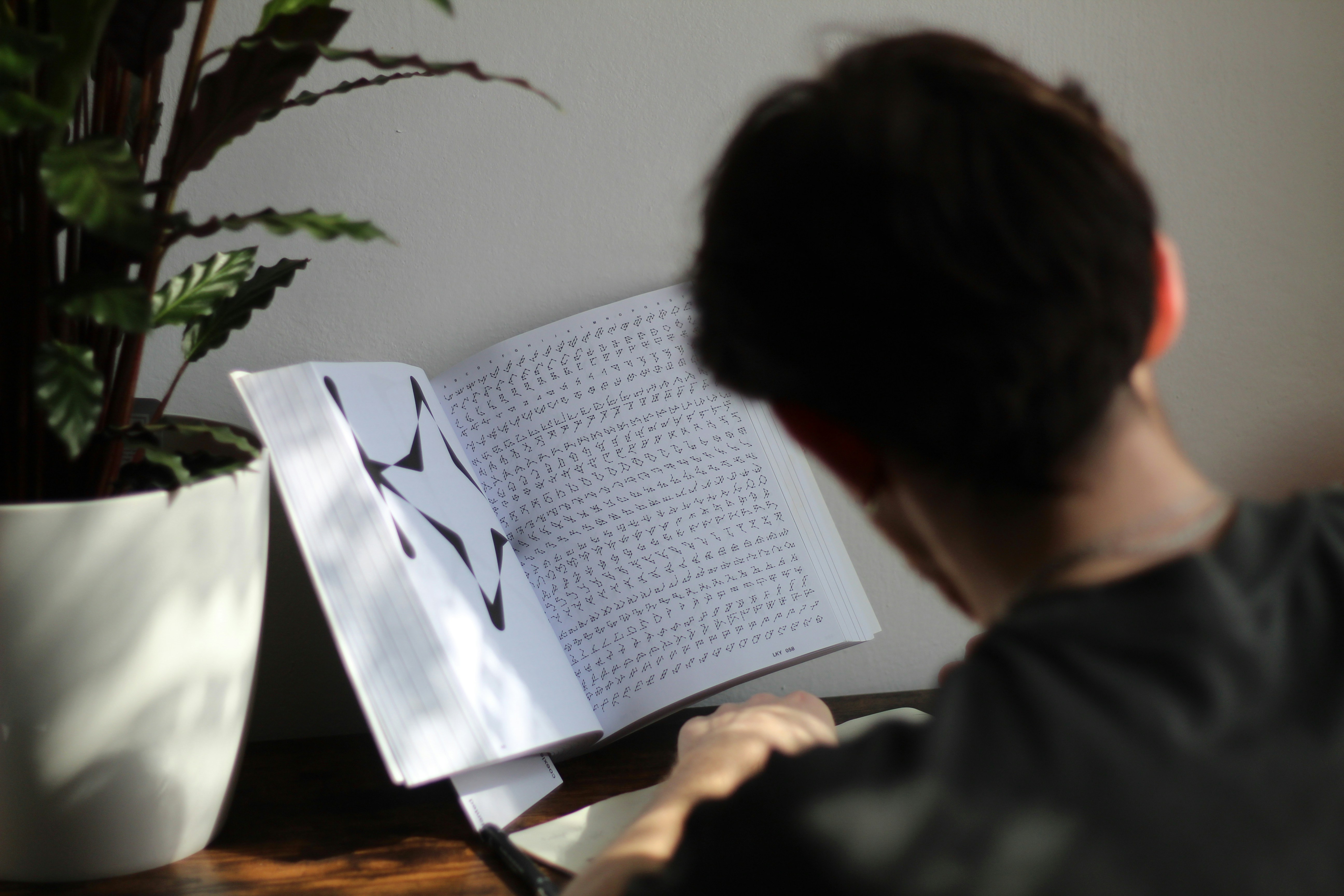 a person sitting at a table reading a book