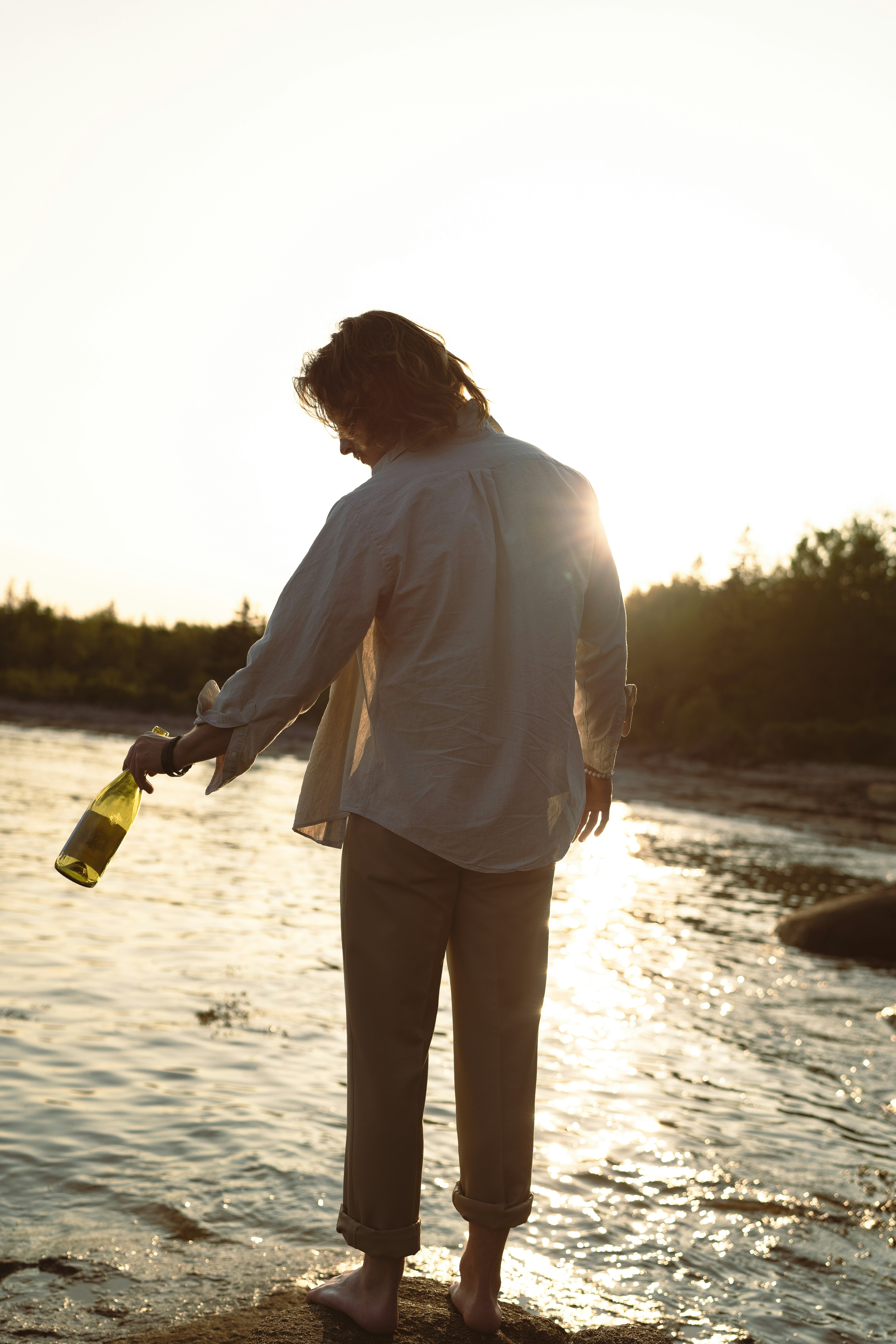 a man standing on a beach next to a body of water
