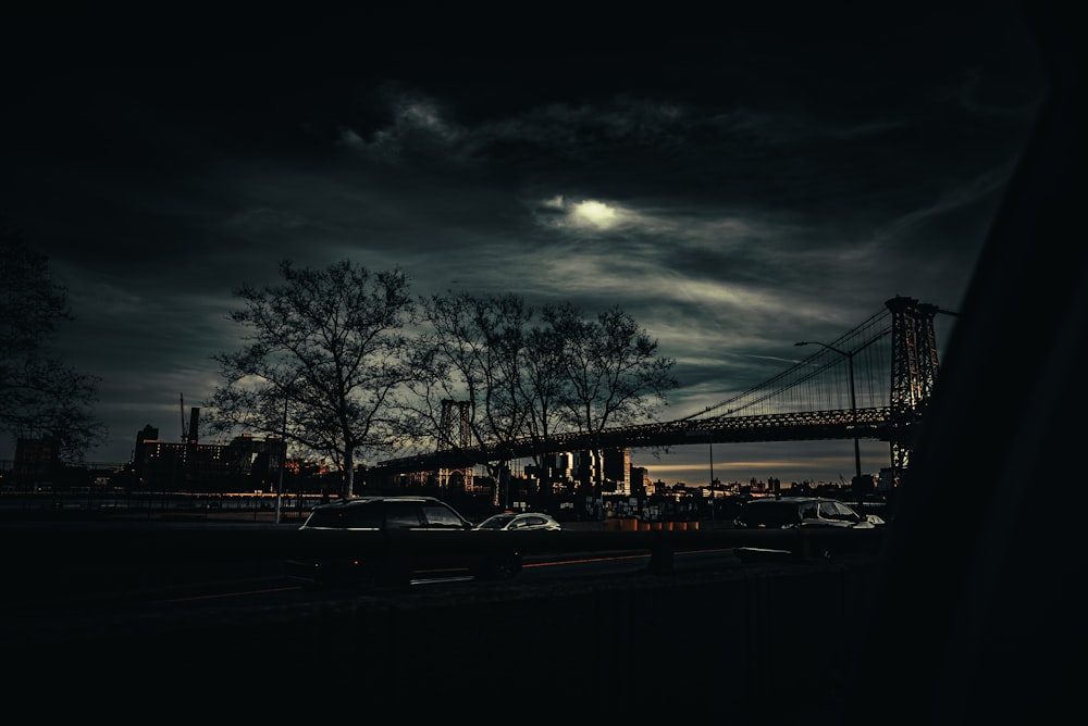 a night scene with a bridge and cars