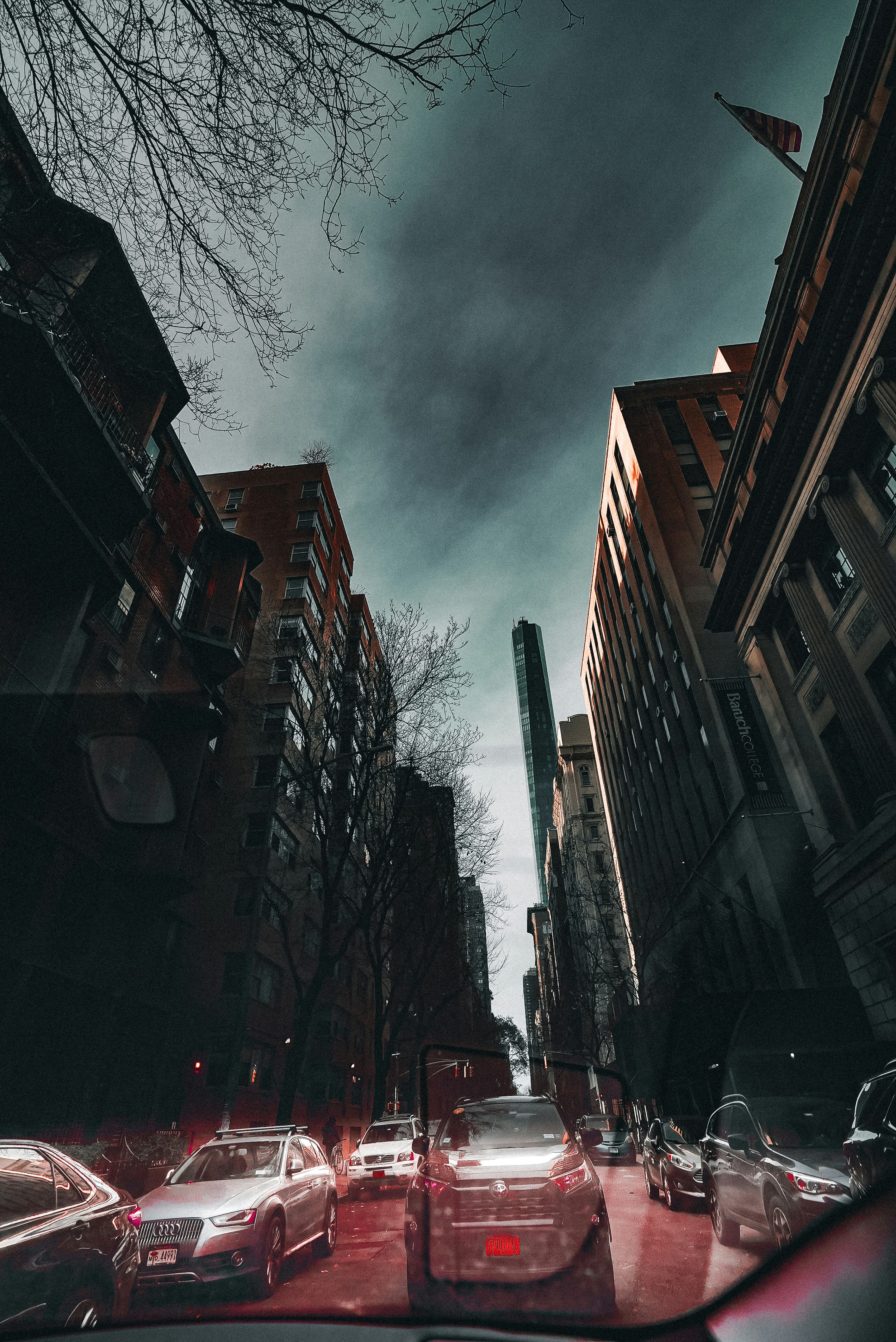 a city street filled with lots of traffic under a cloudy sky