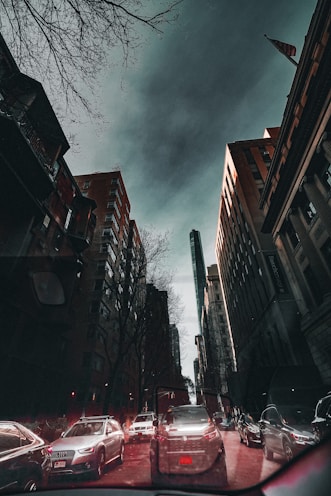 a city street filled with lots of traffic under a cloudy sky