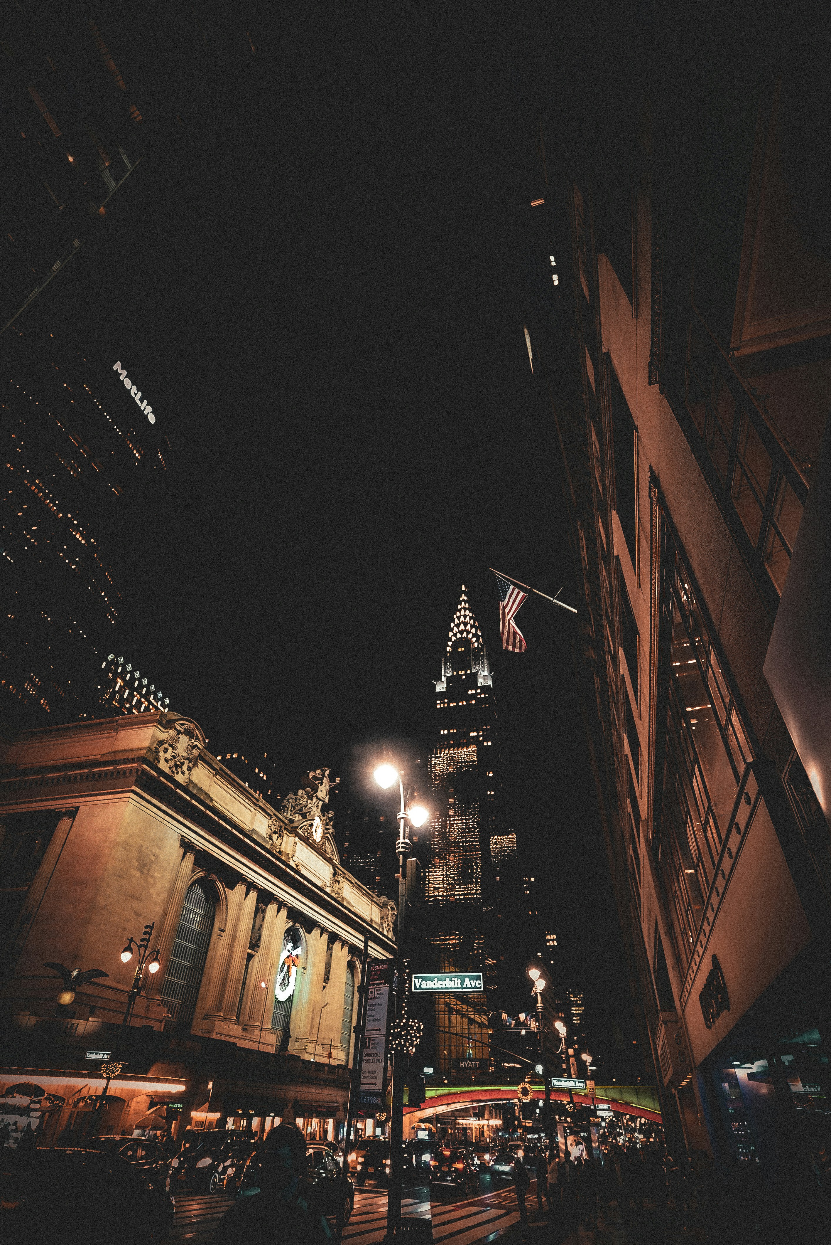 a city street at night with a tall building in the background