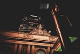 A nighttime view of an illuminated historic building facade with classical architectural details, featuring a clock and sculptures. Above the structure, a modern skyscraper displays the glowing MetLife logo. The scene is partially obscured by an out-of-focus street light in the foreground.