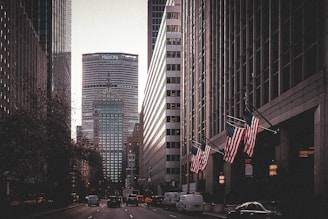 a city street lined with tall buildings and american flags