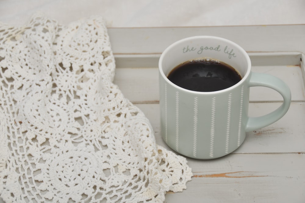 a cup of coffee sitting on top of a white tray