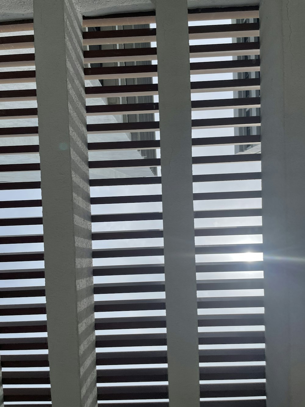 the sun is shining through the blinds of a window