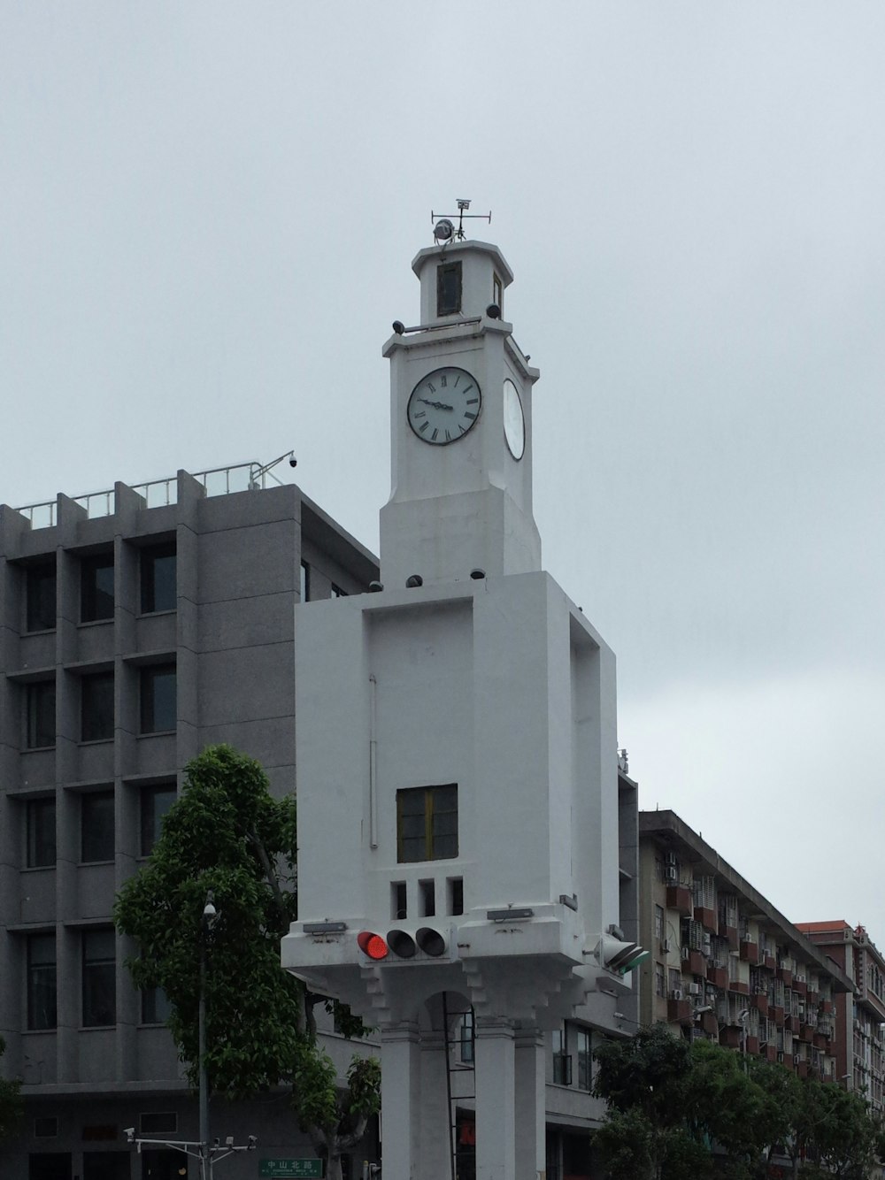 a large white clock tower in the middle of a city