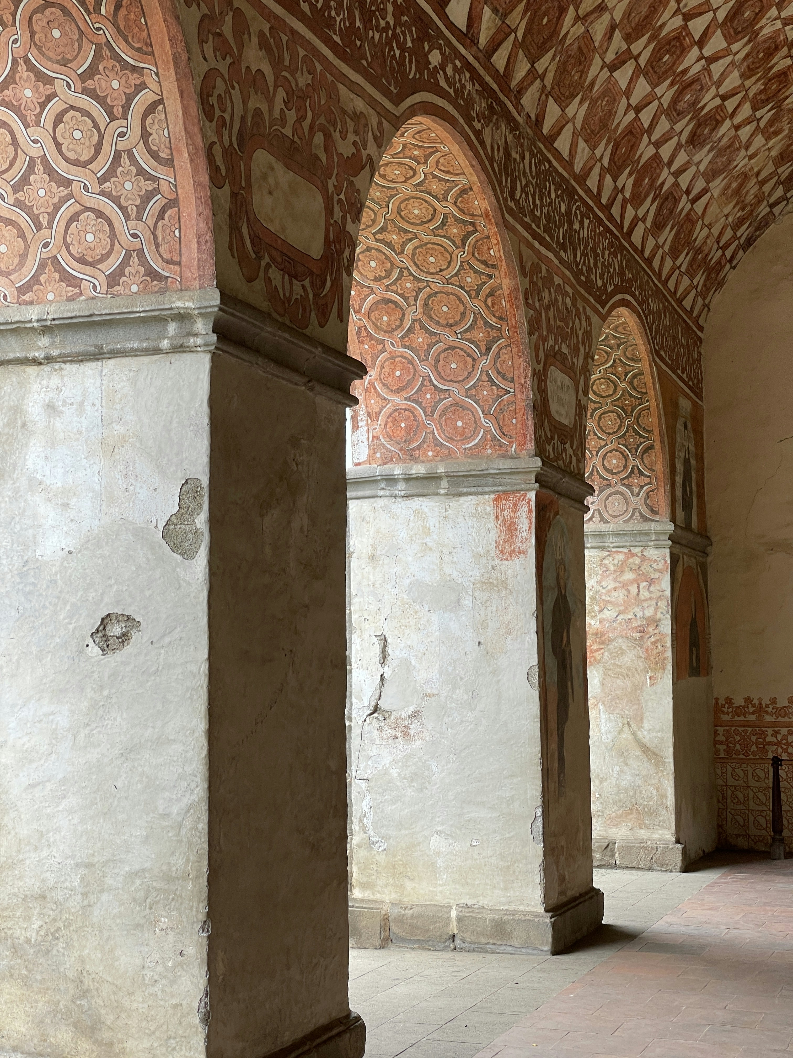 uma grande sala com arcos e um relógio na parede