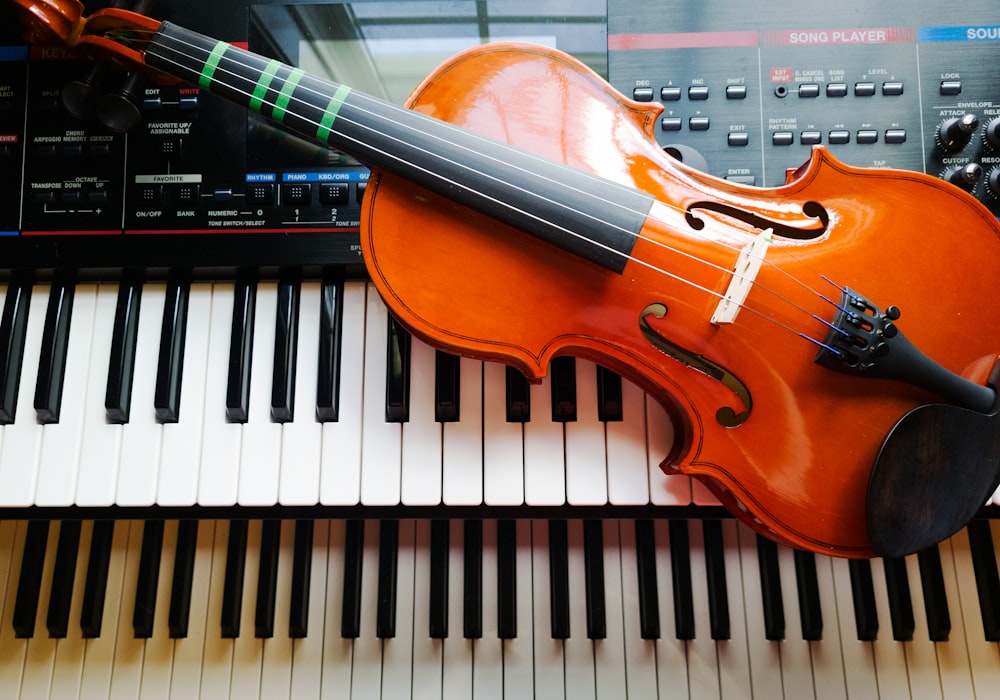 a violin sitting on top of a piano keyboard