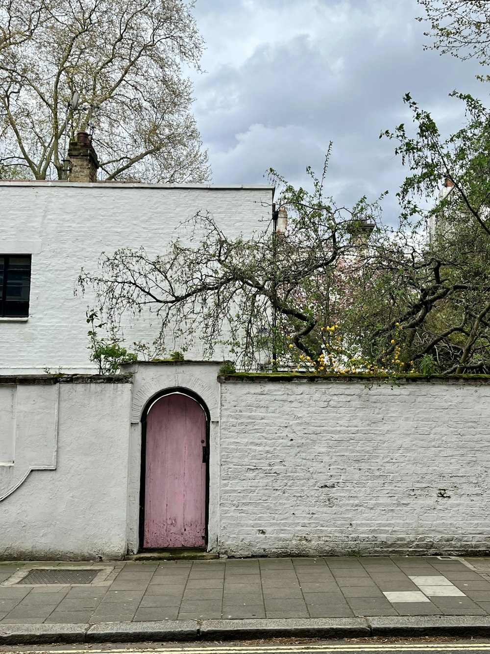 a white brick building with a pink door