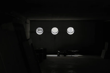 Professional movers handling furniture with care inside a sunlit, minimalist living room.