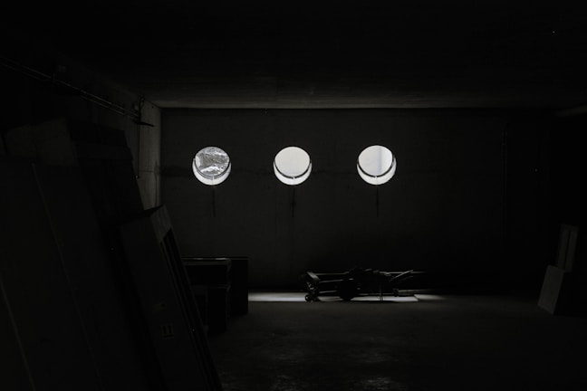 Friendly movers unpacking boxes and arranging furniture in a bright new office space.