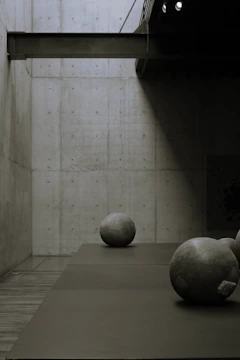 Minimalist interior with dark walls, gold accents, and sculptural furniture.