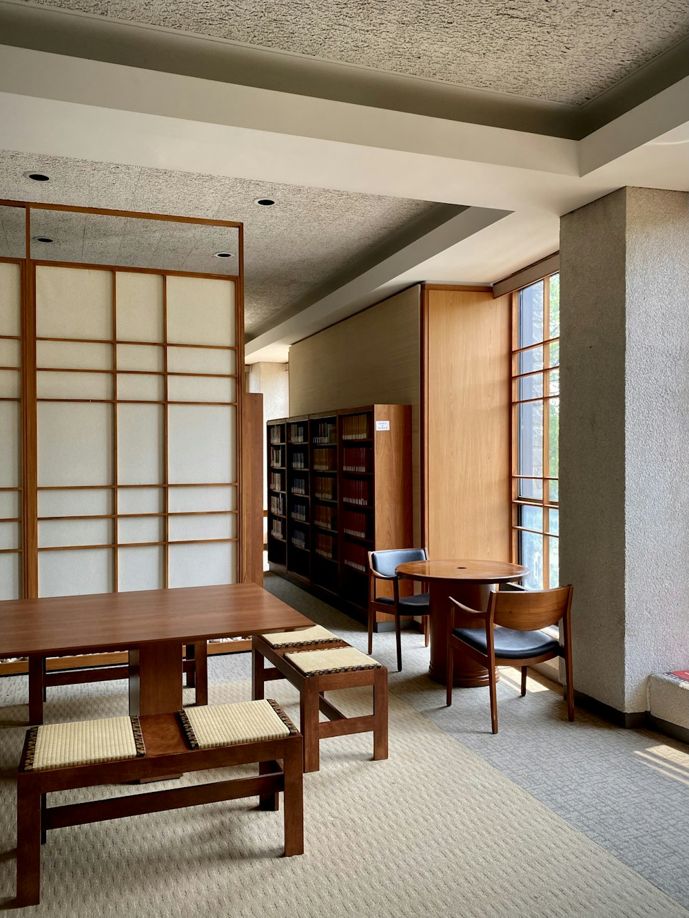 a room with a table, chairs, and bookshelves