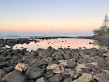 A serene fine art photo of a quiet coastal scene at dawn with pastel colors.