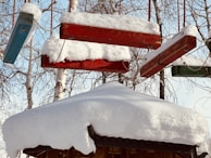 A collection of colorful atikluks hanging against a snowy Alaskan backdrop.