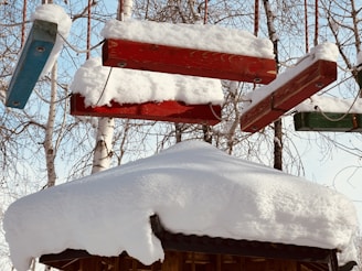 A collection of colorful atikluks hanging against a snowy Alaskan backdrop.
