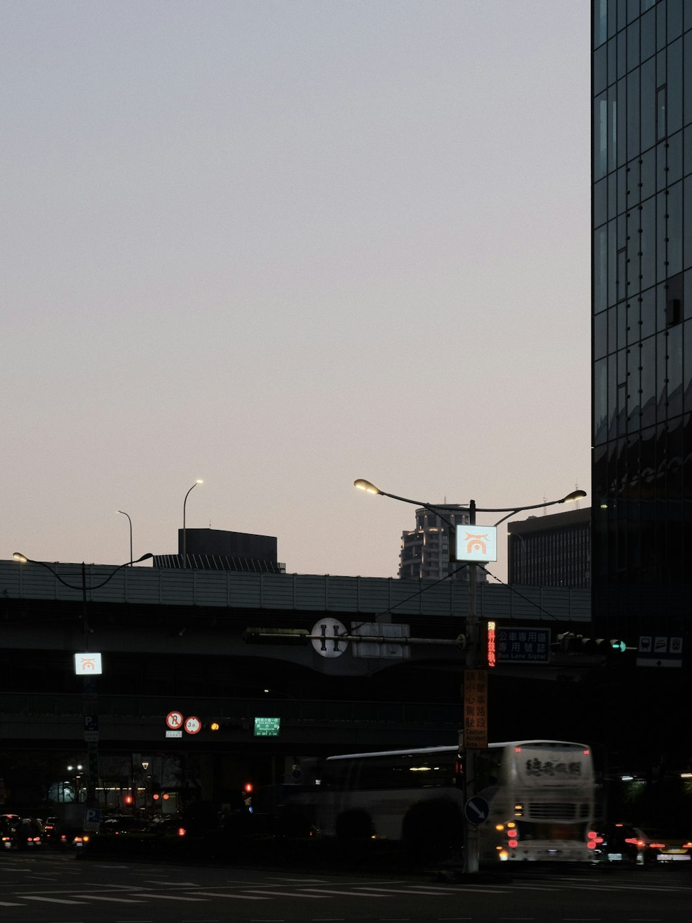 a city street filled with lots of traffic next to tall buildings