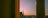 Elegant hotel room with a large window overlooking Paris skyline at sunset.