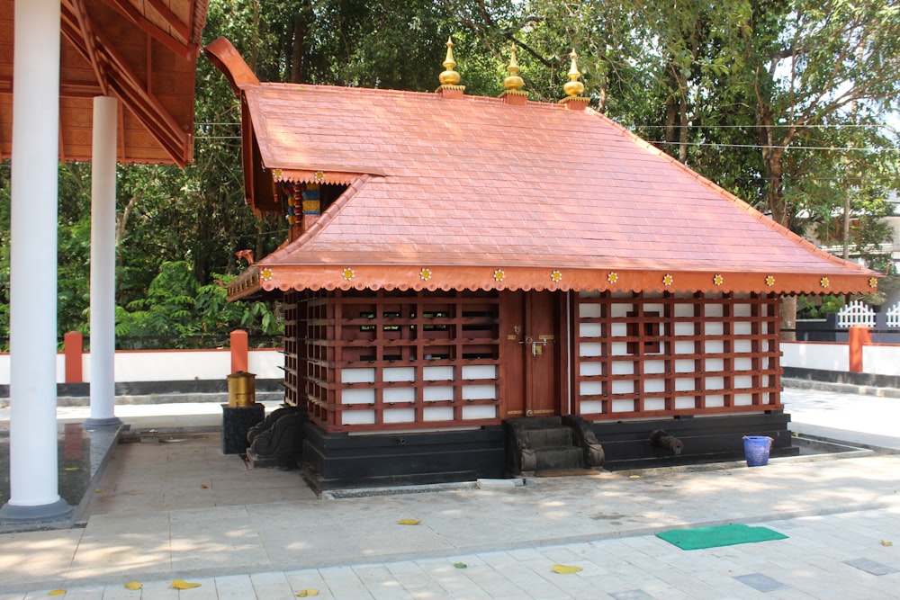 a small wooden building with a red roof