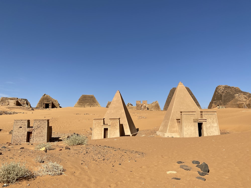 um grupo de pirâmides sentado no meio de um deserto