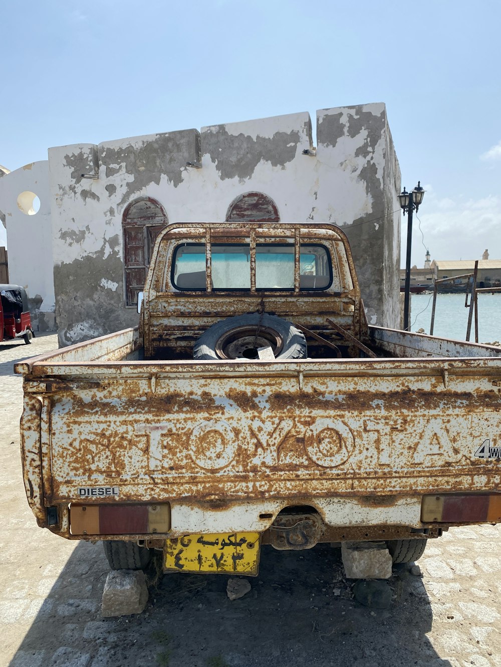 an old rusted truck parked in front of a building