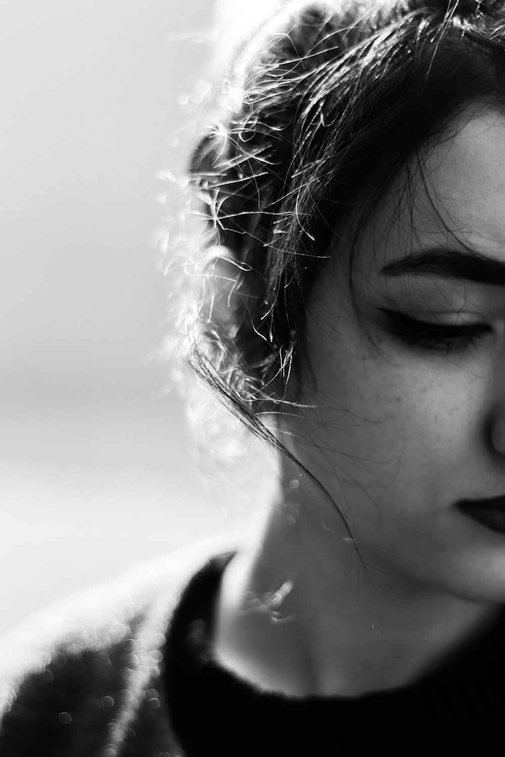 a black and white photo of a woman with her eyes closed