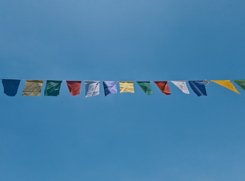 a row of multicolored flags hanging from a line