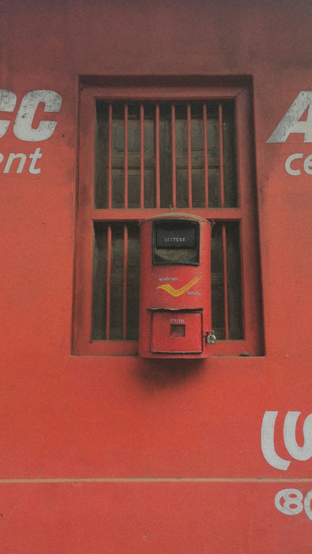 鉄格子の窓とその上の看板のある赤い壁