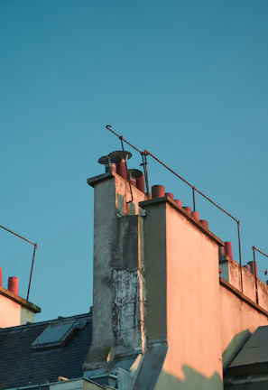 Technician carefully cleaning a chimney flue on a sunny Miami Gardens rooftop.