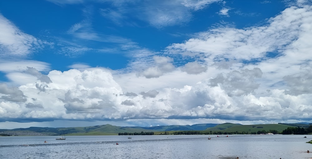 a body of water surrounded by mountains and clouds