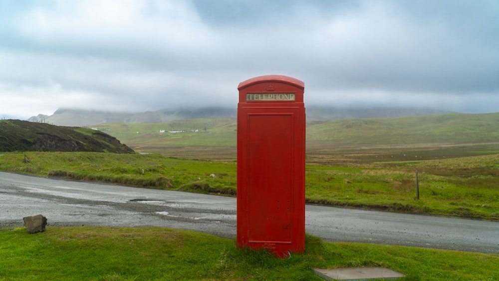 a red post box sitting on the side of a road