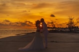 An elegant couple enjoying a sunset dinner on a private terrace with panoramic views of Bora Bora’s lagoon.