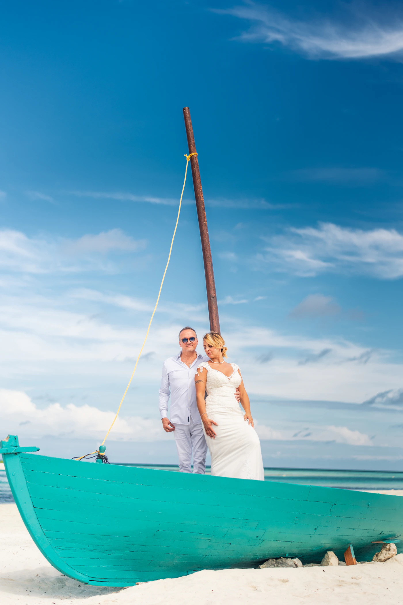 Bride and groom together on a boat by a tropical beach