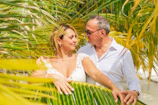 Casual couple portraits with warm afternoon light filtering through palm trees near a luxury Marrakech hotel.
