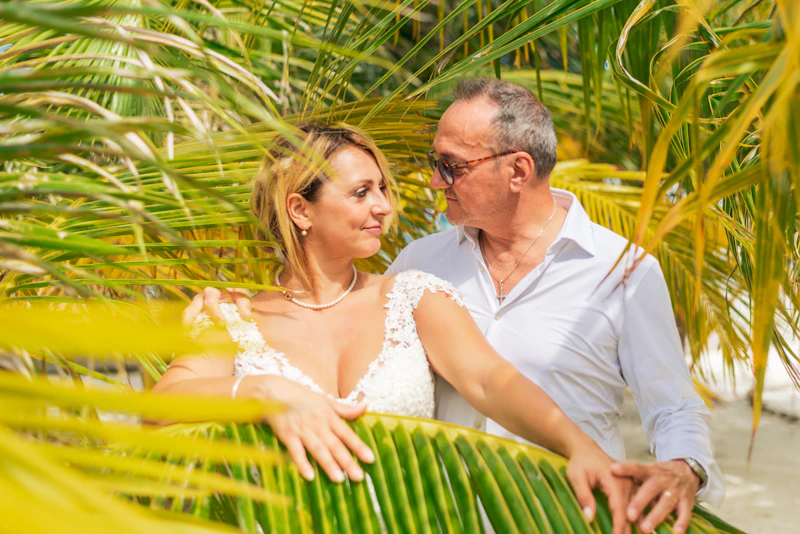 man and woman standing together under palm tree