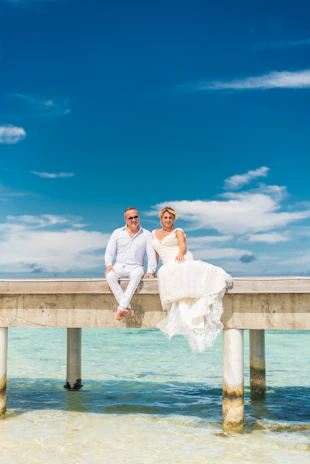 A couple celebrating their honeymoon with a romantic dinner by the ocean.