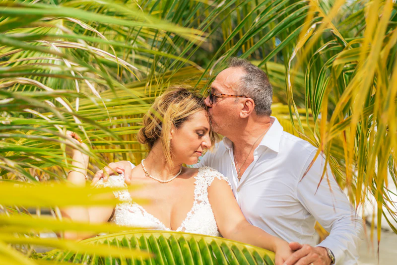 man and woman standing together under palm trees